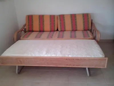 a wooden bench sitting in the corner of a room at Albufeira 1 bedroom apartment 5 min from Falesia beach and close to center L in Albufeira