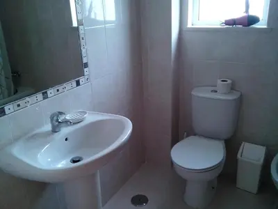 a white bathroom with a toilet and a sink at Albufeira 1 bedroom apartment 5 min from Falesia beach and close to center L in Albufeira
