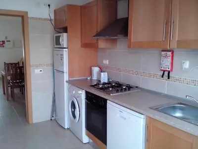 a kitchen with a stove top oven next to a sink at Albufeira 1 bedroom apartment 5 min from Falesia beach and close to center L in Albufeira