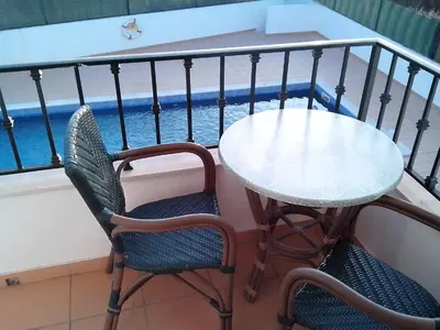 a table and two chairs and a table on a balcony at Albufeira 2 bedroom apartment 5 min from Falesia beach and close to center H in Albufeira