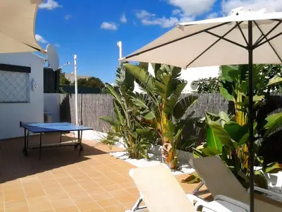 a table and chairs and an umbrella on a patio at Villa 81 great spot Oura beach, Albufeira in Albufeira
