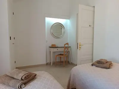 a bedroom with two beds and a desk with a mirror at Villa 81 great spot Oura beach, Albufeira in Albufeira