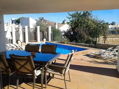 a patio with a table and chairs and a pool at Villa 81 great spot Oura beach, Albufeira in Albufeira