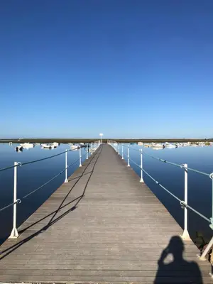 a shadow of a person standing on a pier at The Portuguese Element in Faro