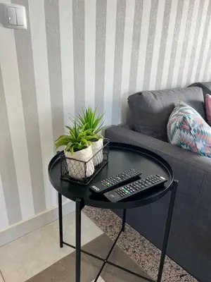 a coffee table with two remote controls and a couch at Villa Adrian & Brian in Albufeira