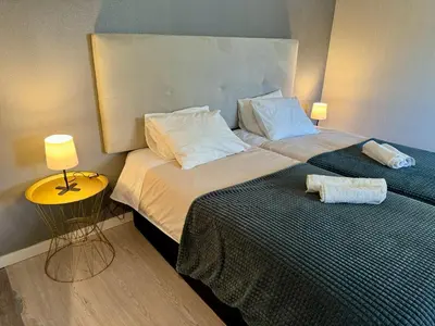 a hotel room with two beds and a night stand at Villa Quévin in Albufeira