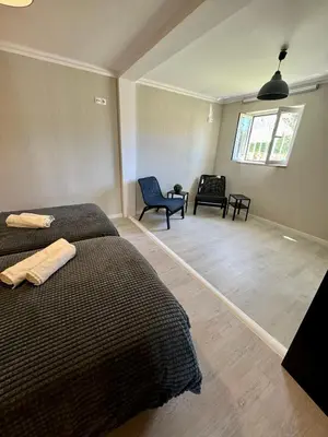 a bedroom with a bed and two chairs and a window at Villa Quévin in Albufeira