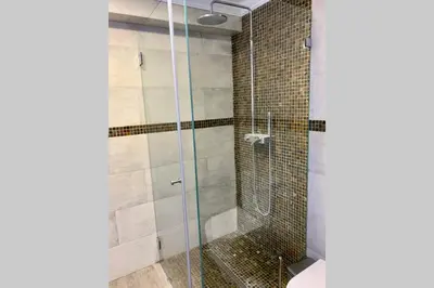 a bathroom with a glass shower with a toilet at Villa Quévin in Albufeira