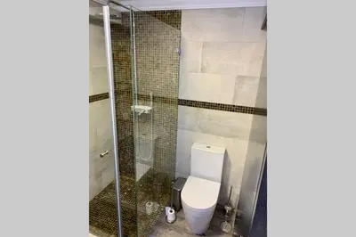 a bathroom with a toilet and a glass shower at Villa Quévin in Albufeira