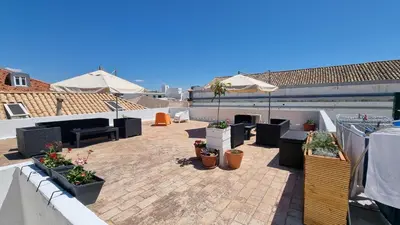 a patio with potted plants on a roof at Happen!ng in Faro