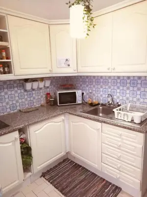 a kitchen with white cabinets and a sink and a microwave at Happen!ng in Faro