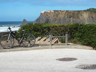 a bike is parked next to the beach at Happen!ng in Faro