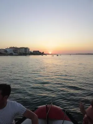 a group of people on a boat in the water at sunset at Happen!ng in Faro
