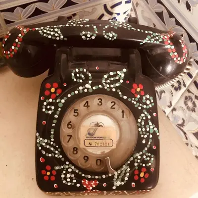a telephone is decorated with flowers and a clock at Happen!ng in Faro