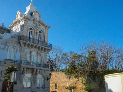a white building with a clock tower on top of it at Happen!ng in Faro