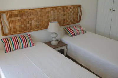two beds in a room with a lamp on a table at Villa 2, great spot Oura beach, Albufeira in Albufeira