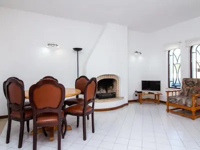 a living room with a table and chairs and a fireplace at Areias Apartment by Stay ici Algarve Holiday Rental in Albufeira