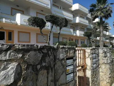 a building with trees on top of a stone wall at Jardim Paraiso Apartments in Albufeira