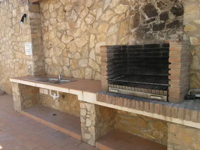 a kitchen with a sink and a stone wall at Jardim Paraiso Apartments in Albufeira
