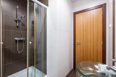a bathroom with a glass shower and a sink at Villa Orada in Albufeira