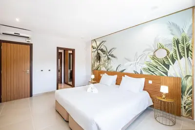 a bedroom with a large white bed with a mural at Villa Orada in Albufeira