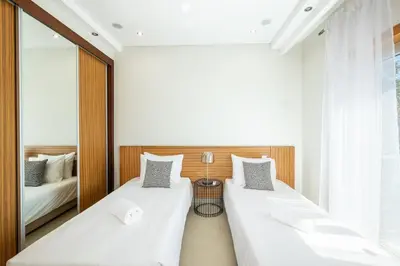 two beds in a room with a mirror at Villa Orada in Albufeira