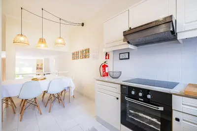 a kitchen with a table and a stove top oven at All Dreams Apartment - Urbanização Windmill in Albufeira