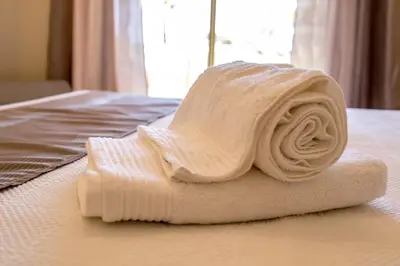 a rolled up white towel on a bed at Marina Garden Apartment in Albufeira