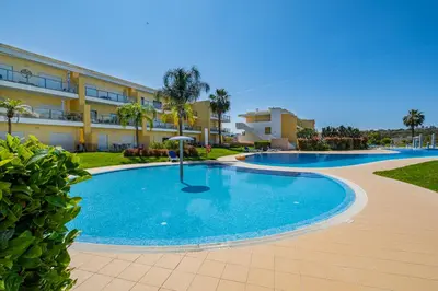 a swimming pool in front of a building at Marina Garden Apartment in Albufeira