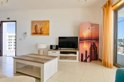 a living room with a tv and a table at Penthouse Apartment, Superb sea view 1 Bedroom, Verandas do Mar AT02 in Albufeira