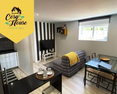 a living room with a couch a table and a tv at Cosy House in Albufeira
