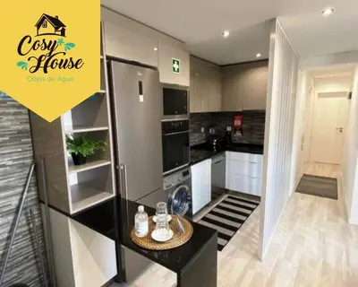 a kitchen with a refrigerator and a table in it at Cosy House in Albufeira
