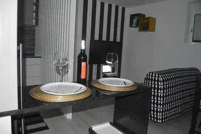 a table with two plates and a bottle of wine at Cosy House in Albufeira