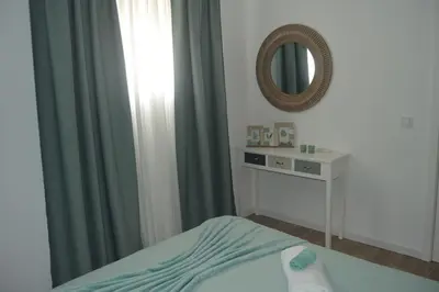 a bedroom with a bed and a mirror at Cosy House in Albufeira