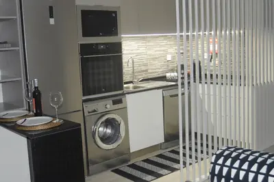 a kitchen with a sink and a washing machine at Cosy House in Albufeira