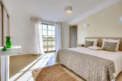 a bedroom with a bed and a large window at Villa Machado in Albufeira