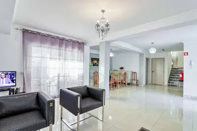 a living room with two chairs and a chandelier at Villa Machado in Albufeira