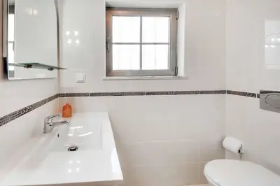 a white bathroom with a sink and a toilet at Villa Machado in Albufeira