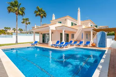 a villa with a swimming pool in front of a house at Villa Minerva in Albufeira
