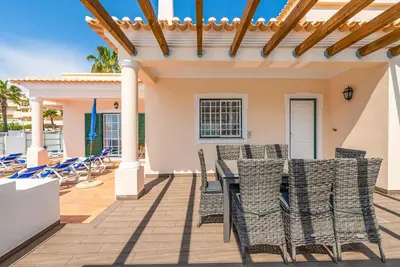 a patio with a table and chairs on a deck at Villa Minerva in Albufeira