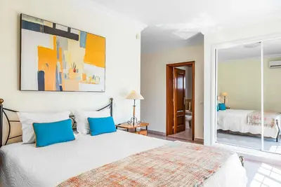 a bedroom with a large white bed with blue pillows at Villa Minerva in Albufeira
