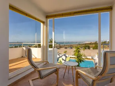a balcony with chairs and a table and a view of the ocean at Villa Villa Blue Ocean by Interhome in Patroves