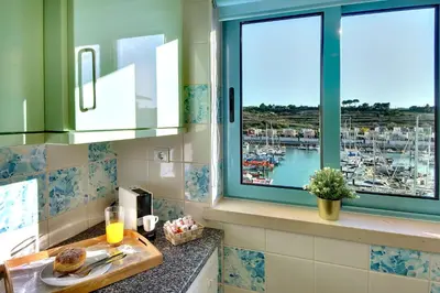 a kitchen with a window with a view of a marina at Marina Ocean Residence in Albufeira