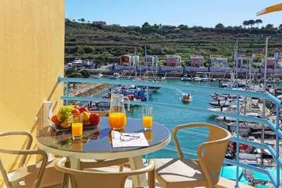 a table with fruit and juice on a balcony with a harbor at Marina Ocean Residence in Albufeira