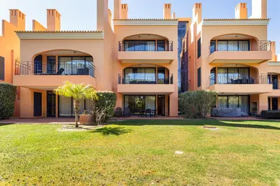 a large building with a yard in front of it at AL - Apartamento Vila Sol F5 E in Vilamoura