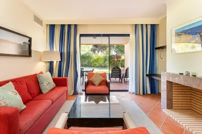 a living room with a red couch and a fireplace at AL - Apartamento Vila Sol F5 E in Vilamoura