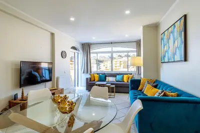 a living room with a blue couch and a table at Top renoviertes Apartment mit großer Terrasse in Albufeira