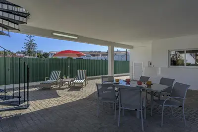 a patio with a table and chairs and an umbrella at FLH Albufeira Vila Mira Flat with Pool in Albufeira