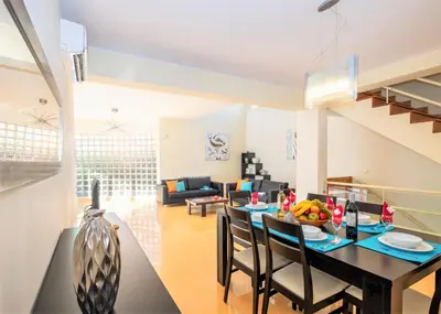 a dining room and living room with a table and chairs at Villa Acapulco by Algarve Vacation in Albufeira