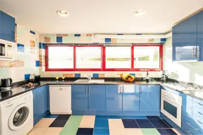 a kitchen with blue cabinets and a washer and dryer at Villa Acapulco by Algarve Vacation in Albufeira